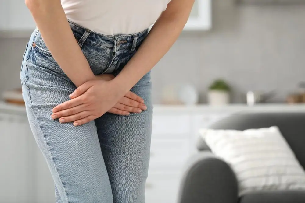 Woman experiencing lower abdominal discomfort while standing