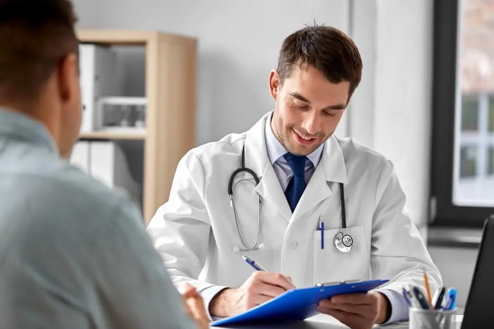 Doctor writing notes during a patient consultation