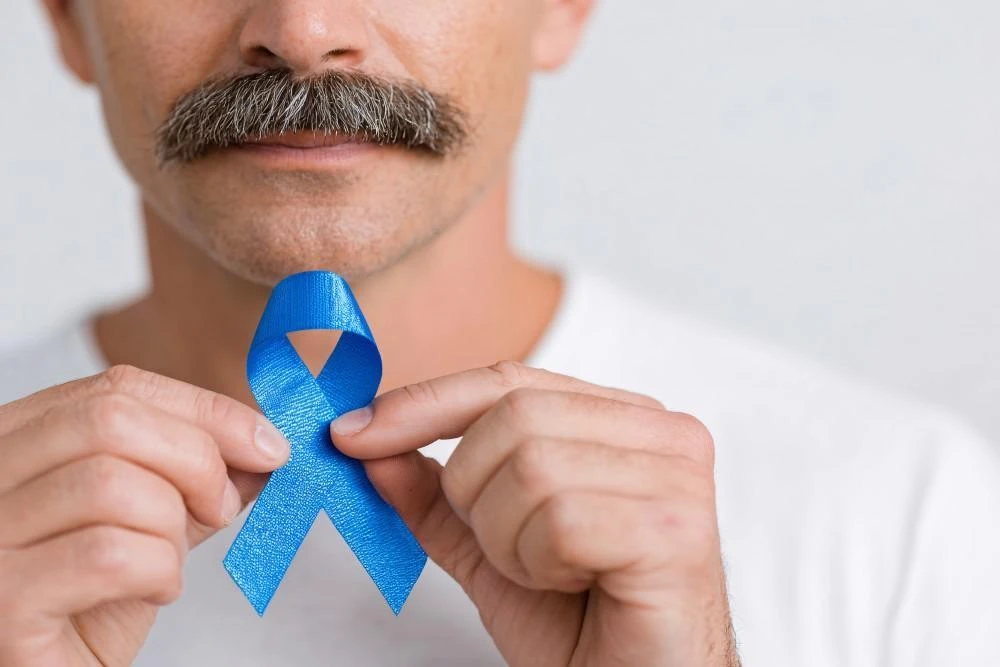 Man holding a blue prostate cancer awareness ribbon