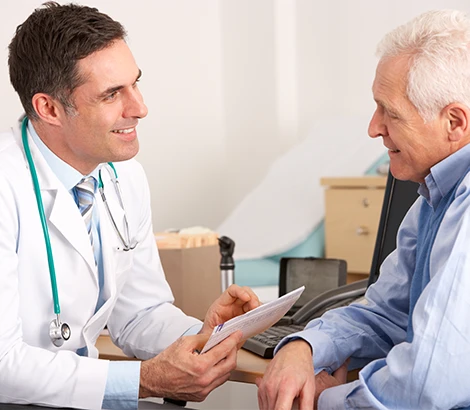 Male doctor speaking with an older male patient during consultation